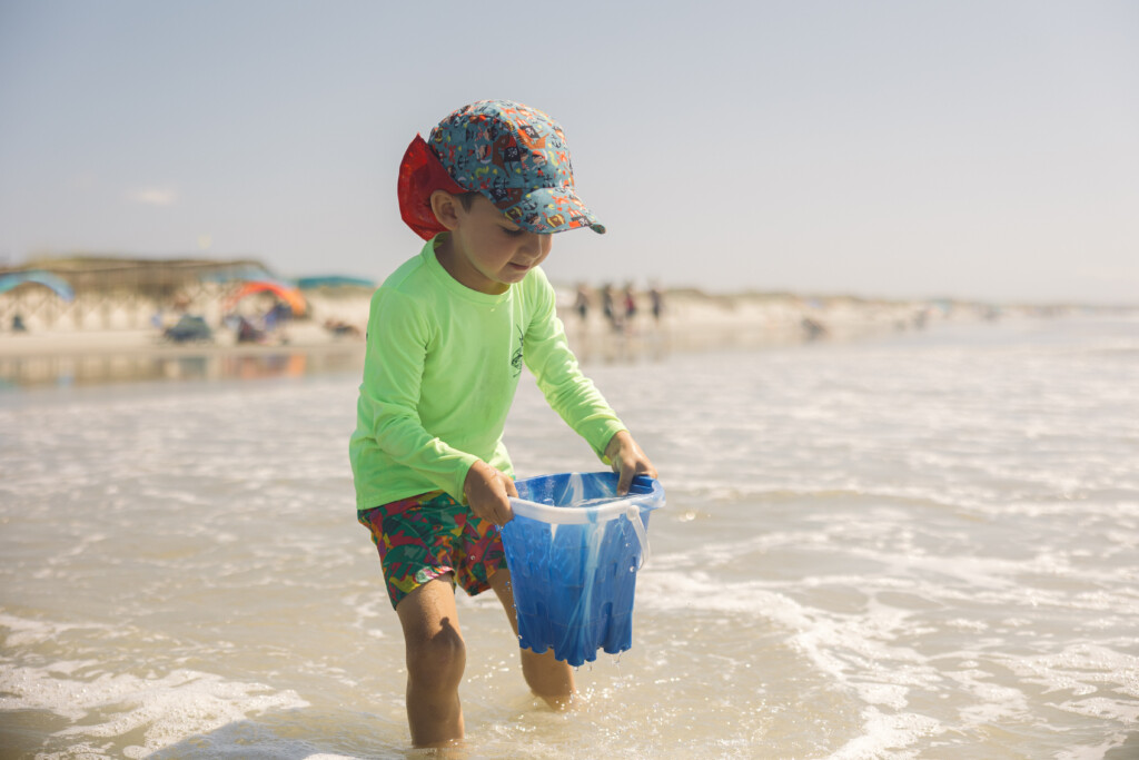 Candid moment of a child running through shallow waves at Sunset Beach, NC.