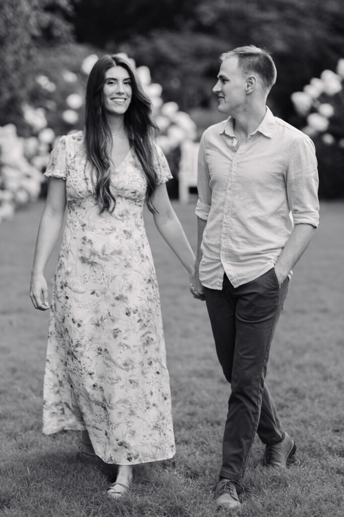 Engaged couple walking along a garden path at Reynolda Gardens in Winston-Salem, NC. North Carolina wedding photographer. Engagement photographer in Winston-Salem NC.