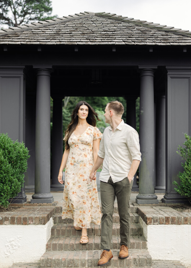 Close-up of couple holding hands in the rose garden at Reynolda Gardens. North Carolina wedding photographer. Engagement photographer in Winston-Salem NC.