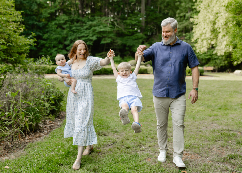 Family photographed among tree-lined paths at the Greensboro Arboretum