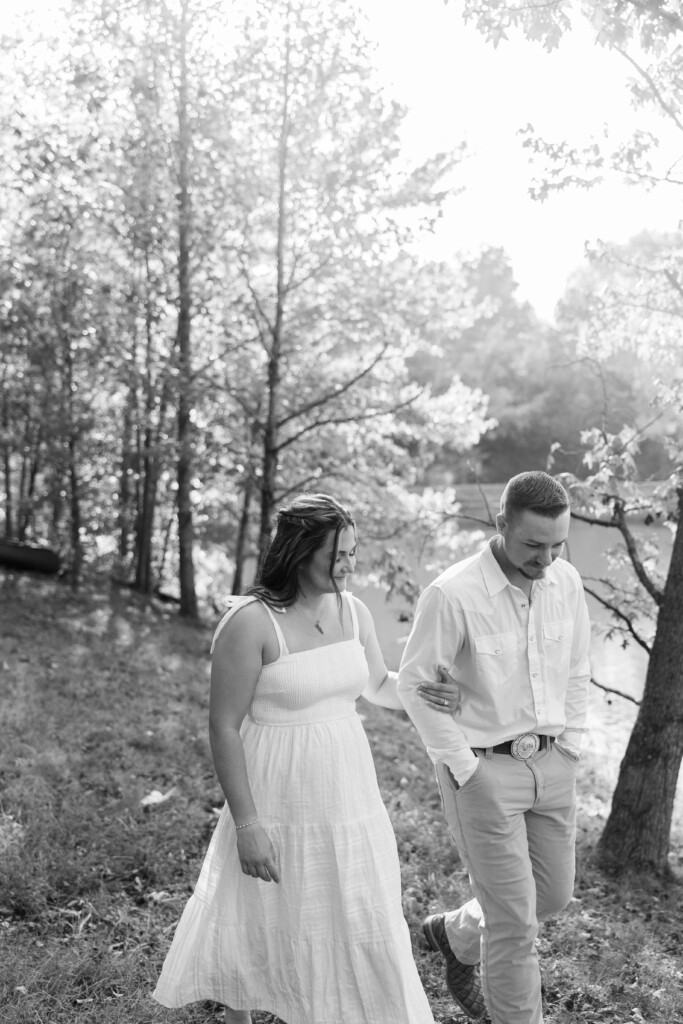 Engaged couple walking through golden hour light at Summerfield Farms in Summerfield, NC